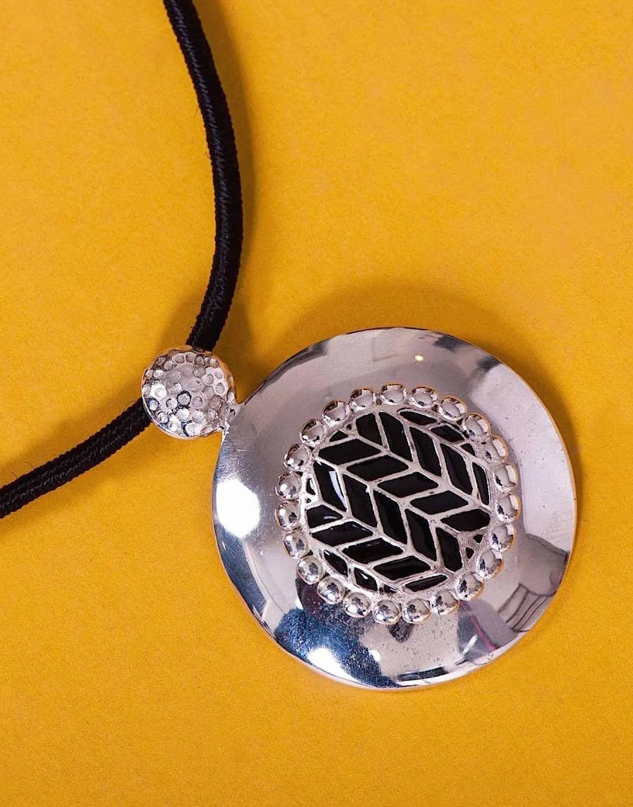 Super chic, round pendant with fine black enamel work center