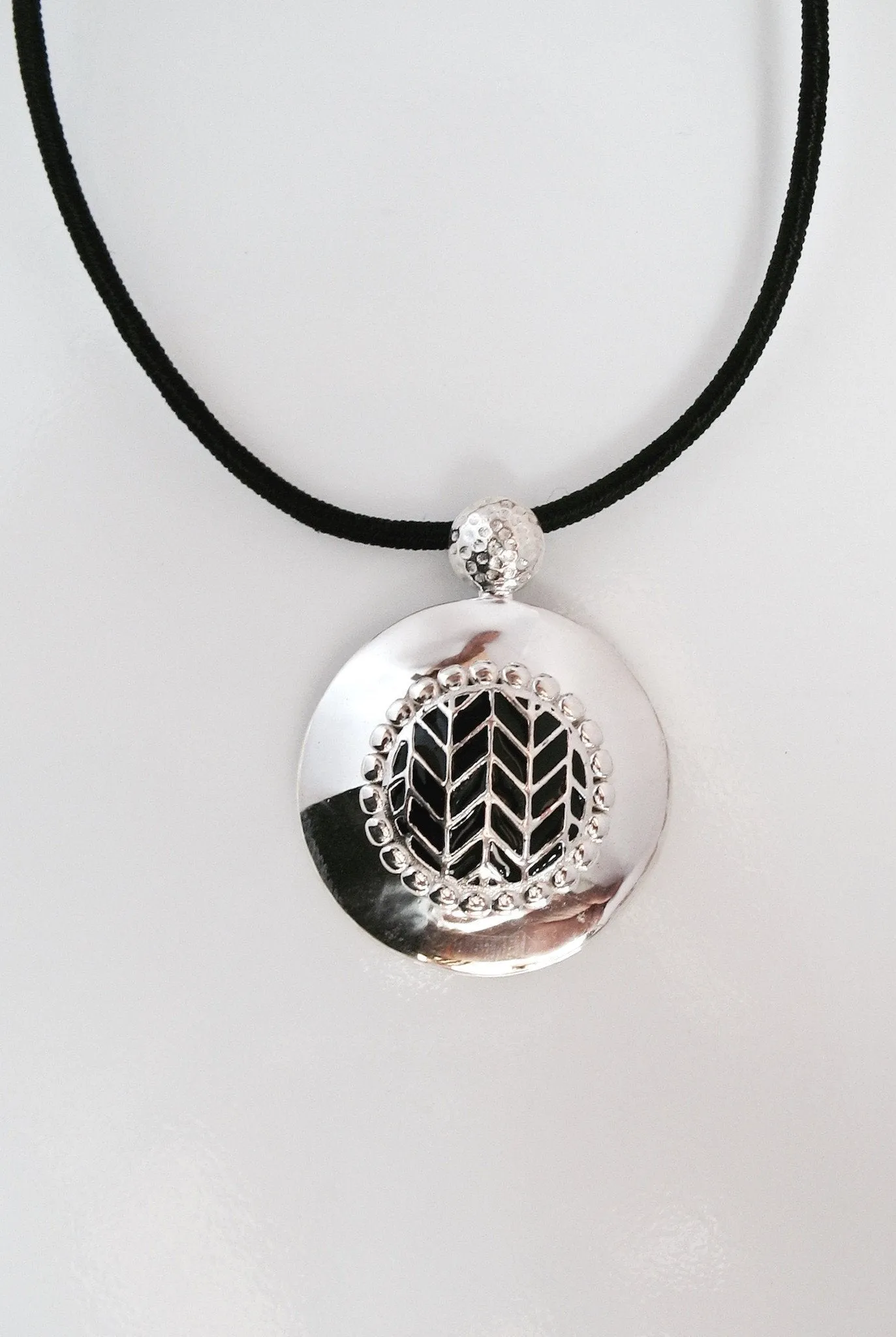 Super chic, round pendant with fine black enamel work center
